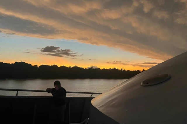 A man checks his cellphone after leaving the port of Breves in a boat in the Marajo region of the Brazilian Amazonia, Para State, Brazil, on December 9, 2024